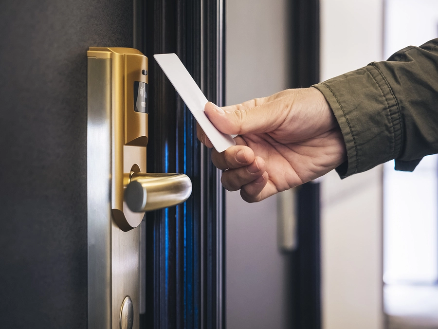 Un homme ouvre la porte de sa chambre avec une clé RFID.